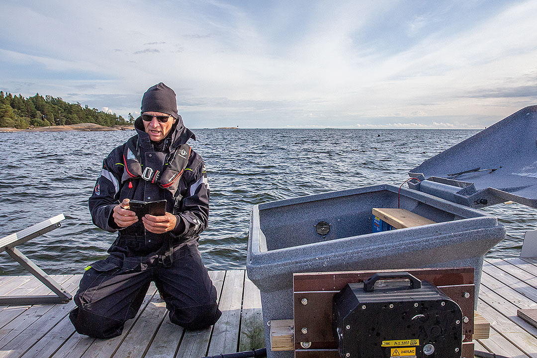 Luonnonvarakeskuksen tutkimusinsinööri Esa Lehtonen tarkastamassa kelluvalle lautalle asennettua hyljekarkotinta merellä.