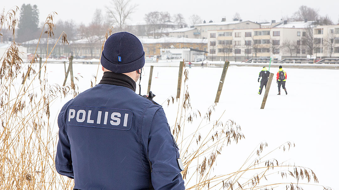 Poliisi valvomassa kalastusta ja kalastusrikkomuksia talvisella joella.