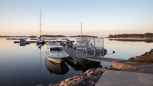 Elokuinen auringonnousu venelaiturilla peilityynellä Suomenlahdella.