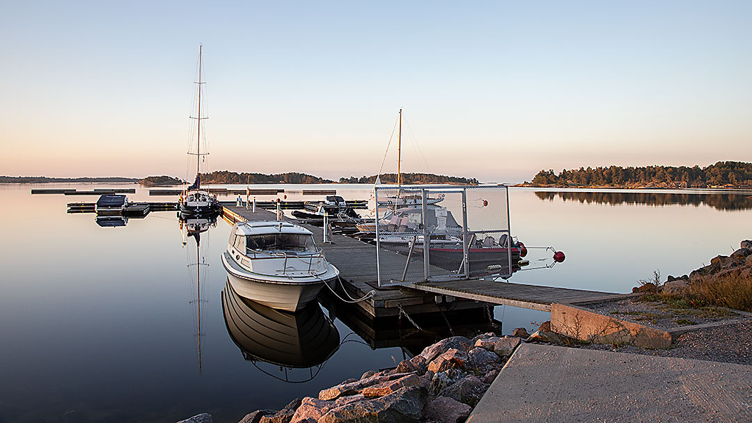 Elokuinen auringonnousu venelaiturilla peilityynellä Suomenlahdella.