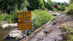 Viereskielisiä kalastajia neuvotaan kalastuspaikalle asetetuilla kylteillä.